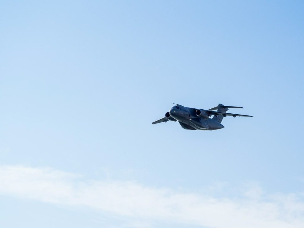 A military aircraft flying in a clear blue sky