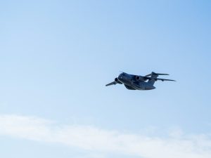 A military aircraft flying in a clear blue sky